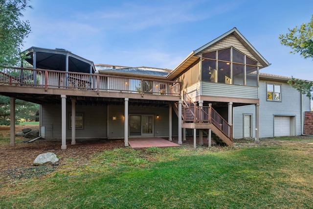 back of property with a sunroom, a wooden deck, a yard, and a patio area