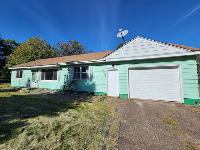 single story home with a front yard and a garage