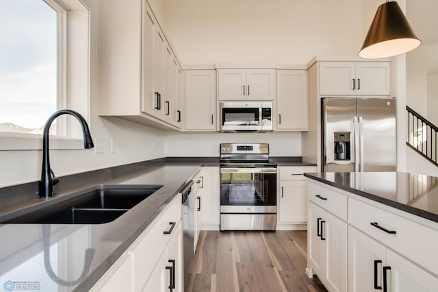 kitchen featuring sink, stainless steel appliances, light wood-type flooring, and plenty of natural light