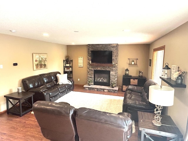 living room featuring hardwood / wood-style floors and a stone fireplace