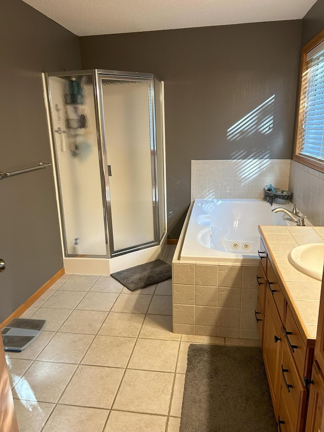 bathroom featuring tile patterned floors, vanity, shower with separate bathtub, and a textured ceiling