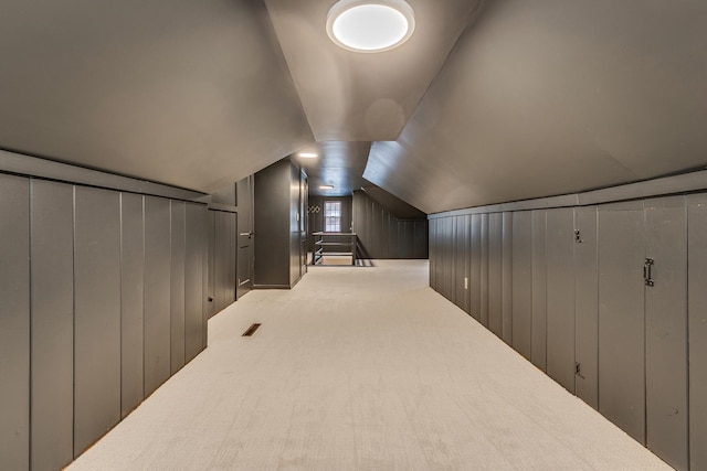 bonus room featuring wooden walls, carpet floors, and vaulted ceiling