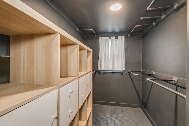 spacious closet with dark tile patterned floors