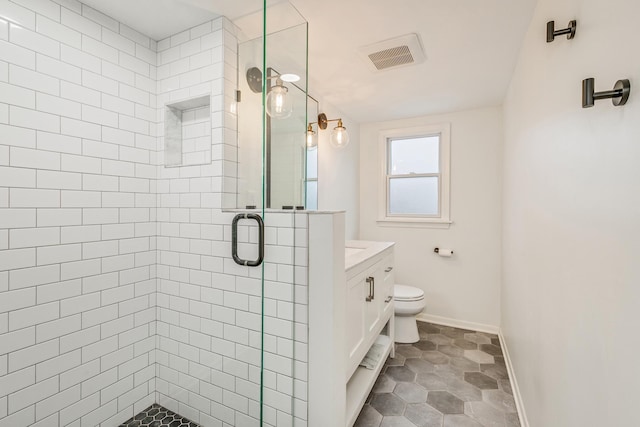 bathroom with tile patterned floors, vanity, toilet, and walk in shower