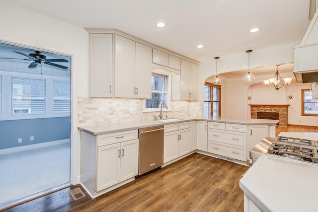 kitchen with kitchen peninsula, decorative backsplash, decorative light fixtures, dishwasher, and dark hardwood / wood-style floors