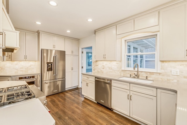 kitchen featuring a healthy amount of sunlight, sink, stainless steel appliances, and dark wood-type flooring