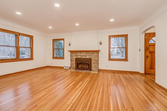 unfurnished living room featuring light wood-type flooring and a fireplace