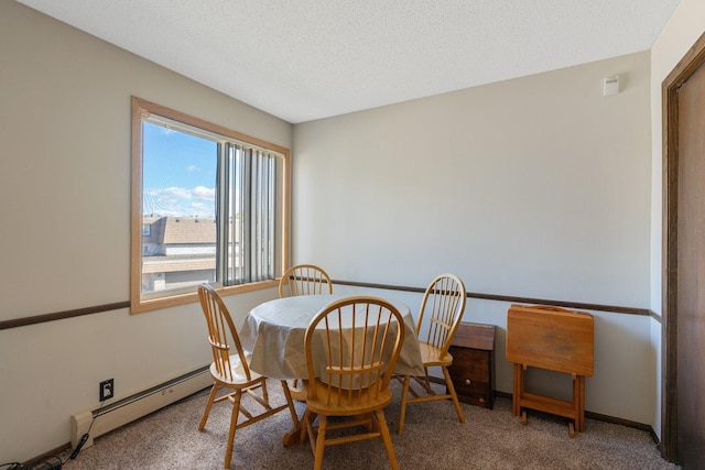 dining area with a baseboard heating unit, carpet, a textured ceiling, and baseboards