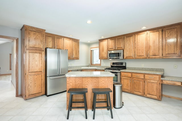 kitchen featuring a center island, sink, stainless steel appliances, and a breakfast bar area