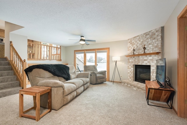 carpeted living room with a textured ceiling, ceiling fan, and a fireplace