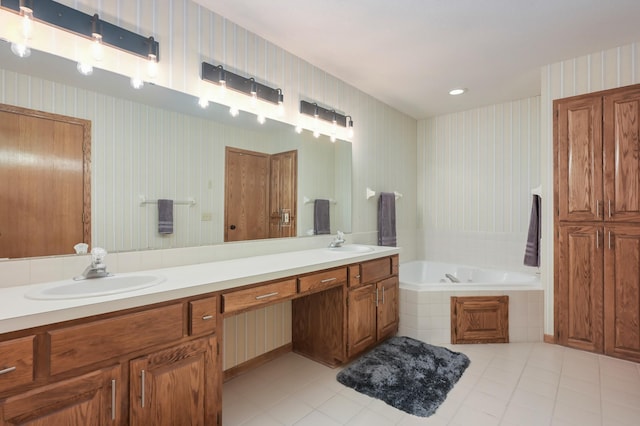 bathroom with tile patterned flooring, vanity, and tiled bath