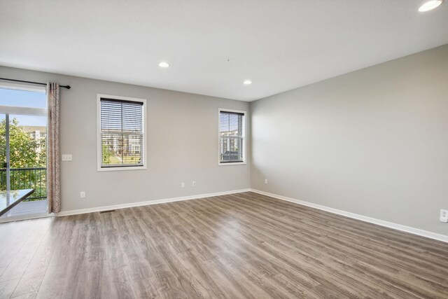 unfurnished room with a wealth of natural light and hardwood / wood-style floors