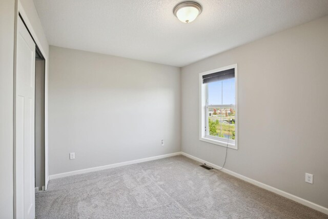 unfurnished bedroom featuring a closet, carpet floors, and a textured ceiling