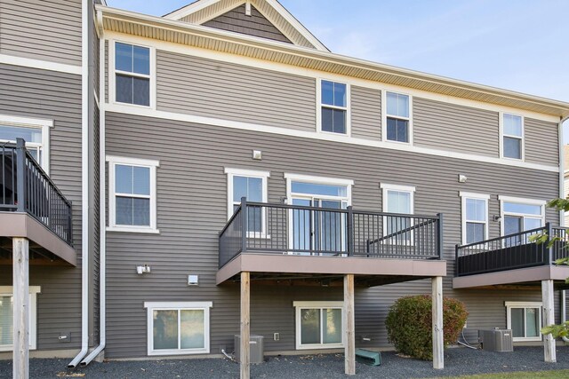 back of house featuring cooling unit and a balcony