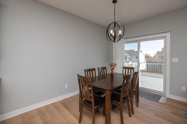 dining space with light hardwood / wood-style flooring and a notable chandelier