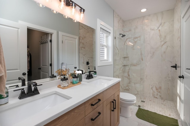 bathroom featuring vanity, toilet, and tiled shower