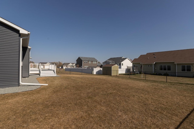 view of yard featuring a storage unit and a wooden deck