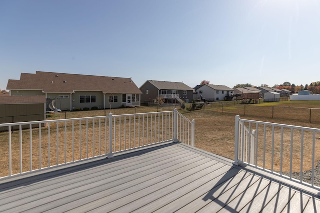 wooden terrace featuring a trampoline and a lawn