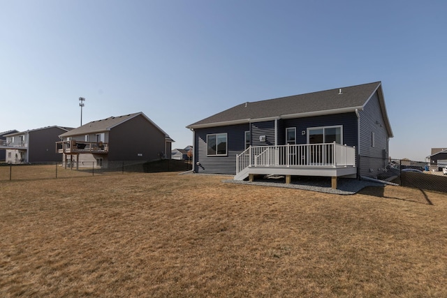 back of property with a wooden deck and a yard