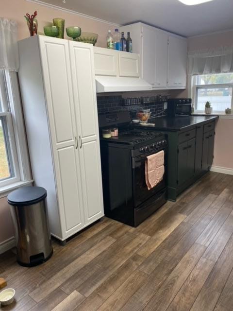 kitchen featuring white cabinets, decorative backsplash, black electric range oven, and dark wood-type flooring