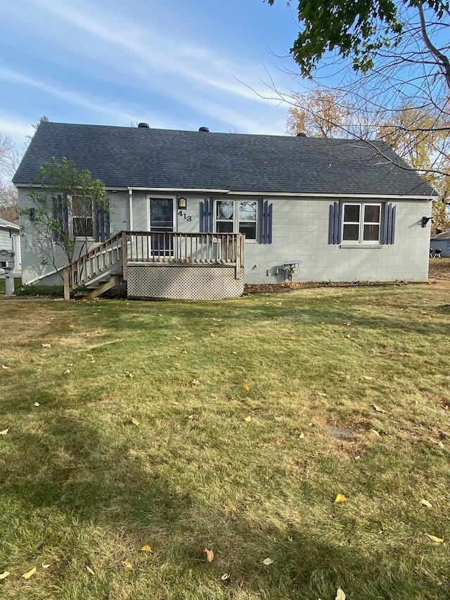 rear view of house featuring a wooden deck and a yard