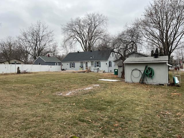 back of house featuring a yard and an outbuilding