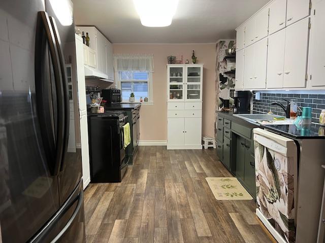 kitchen featuring dishwasher, sink, hardwood / wood-style flooring, white cabinetry, and stainless steel refrigerator