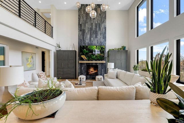 living room featuring a wealth of natural light, a towering ceiling, and a fireplace