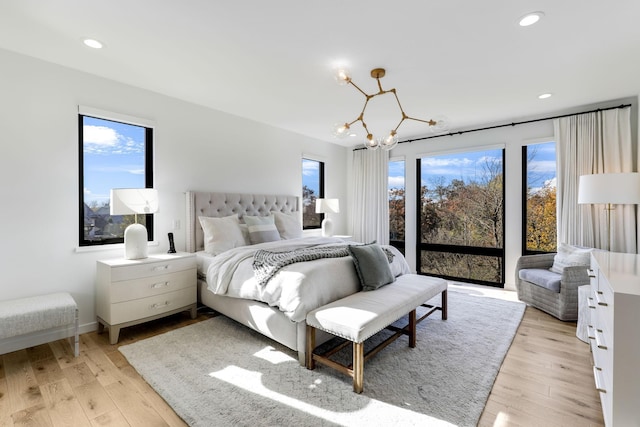 bedroom featuring an inviting chandelier and light hardwood / wood-style flooring