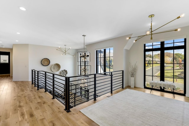 hall with a chandelier and light hardwood / wood-style floors