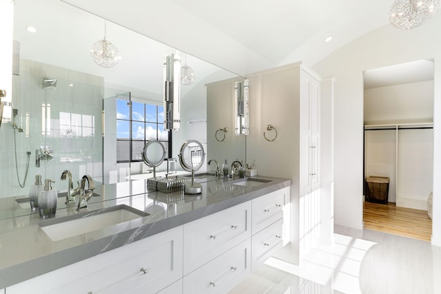 bathroom featuring lofted ceiling, vanity, wood-type flooring, and a shower with door