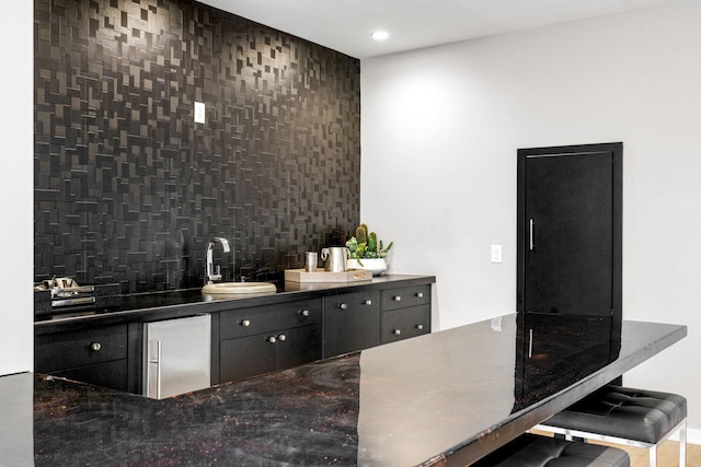 kitchen with refrigerator, backsplash, and sink