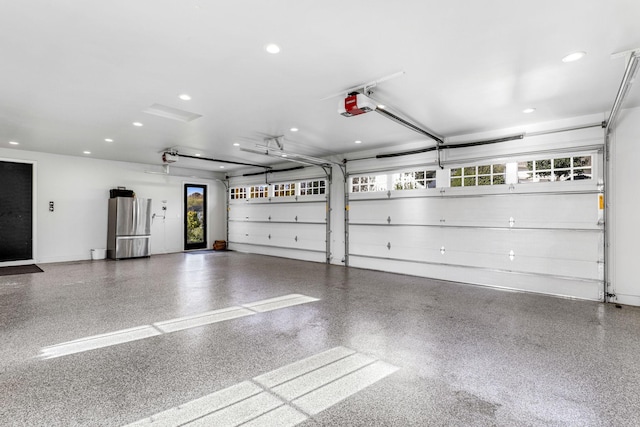 garage featuring a garage door opener and stainless steel refrigerator