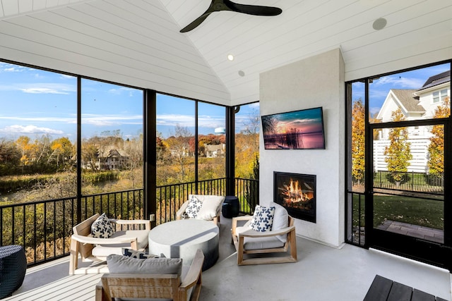 sunroom / solarium with ceiling fan, a wealth of natural light, lofted ceiling, and wood ceiling