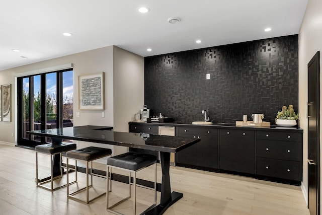 kitchen featuring light wood-type flooring and a kitchen bar