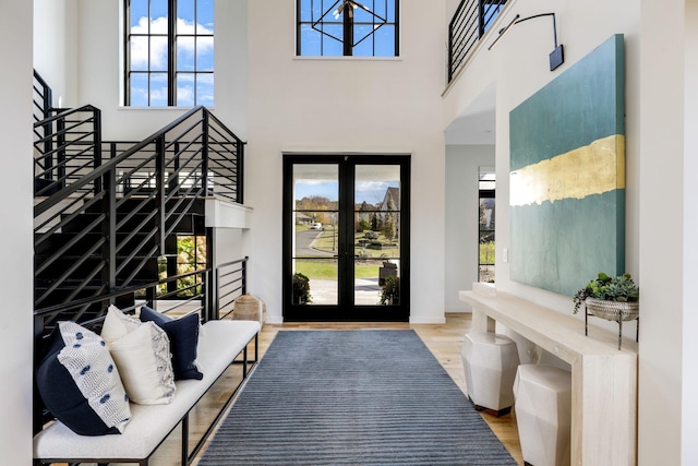 entrance foyer with hardwood / wood-style flooring, a high ceiling, and french doors