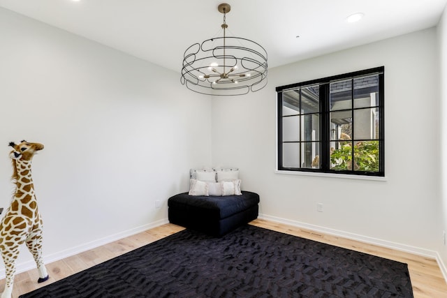 living area with hardwood / wood-style floors and a notable chandelier