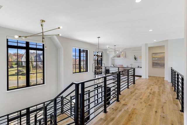 corridor featuring light hardwood / wood-style flooring and a notable chandelier