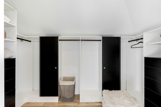 spacious closet featuring lofted ceiling and light hardwood / wood-style flooring