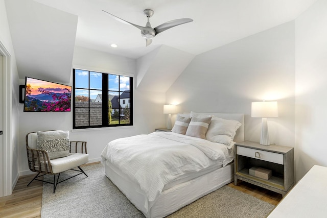 bedroom with vaulted ceiling, ceiling fan, and light wood-type flooring