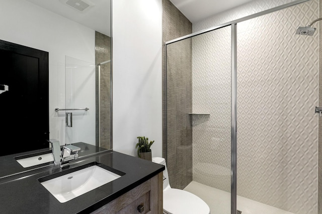 bathroom featuring toilet, vanity, and an enclosed shower