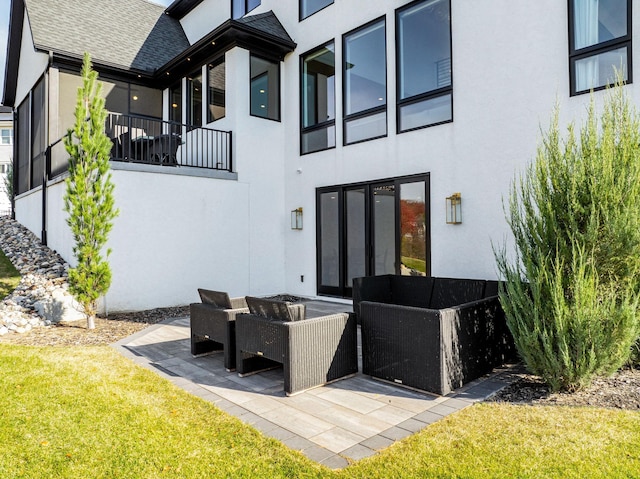 rear view of house with a patio area, outdoor lounge area, and a lawn