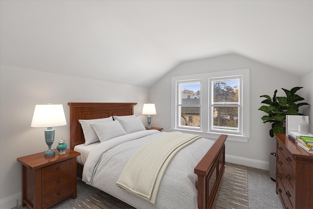 bedroom featuring lofted ceiling and dark carpet