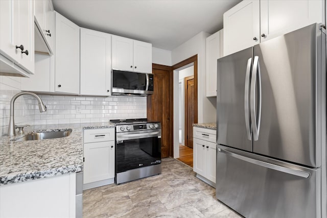 kitchen featuring sink, white cabinets, light stone counters, and stainless steel appliances