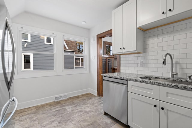 kitchen featuring stainless steel appliances, backsplash, sink, white cabinets, and light stone counters