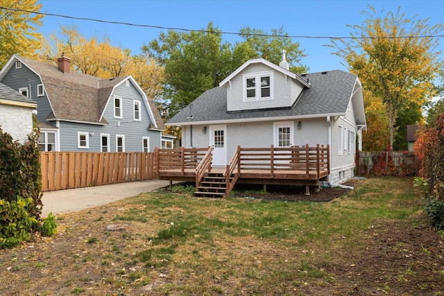 rear view of house with a deck and a lawn