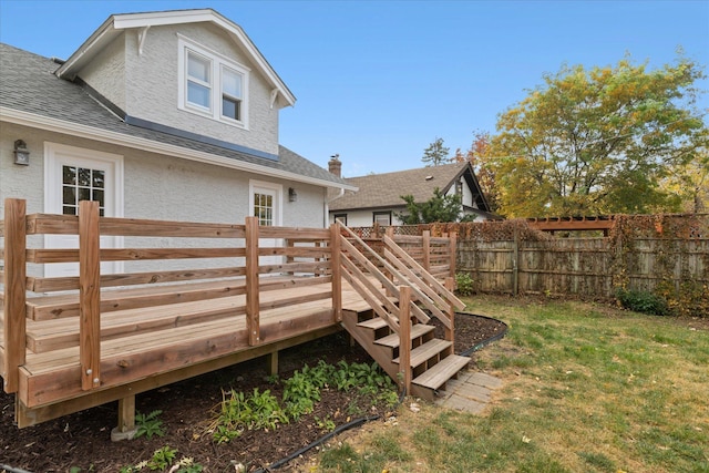 back of house featuring a wooden deck and a lawn