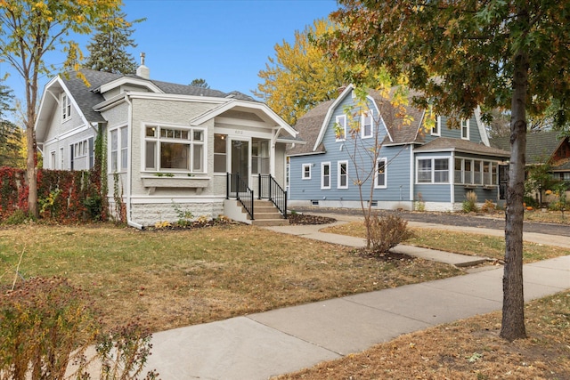 bungalow-style house with a front lawn and a sunroom