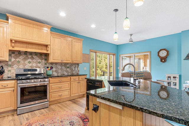 kitchen with light brown cabinetry, tasteful backsplash, sink, stainless steel range with gas cooktop, and hanging light fixtures