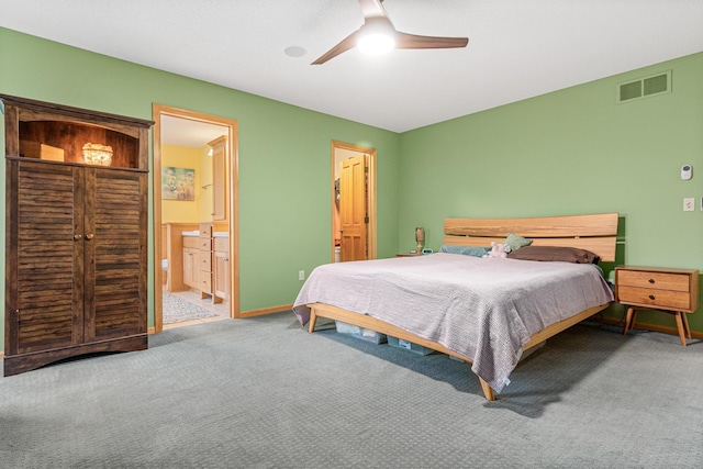 carpeted bedroom with ensuite bathroom and ceiling fan